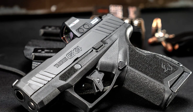 Taurus GX4 com micro red dot instalado no slide, ao lado de coldre e munição