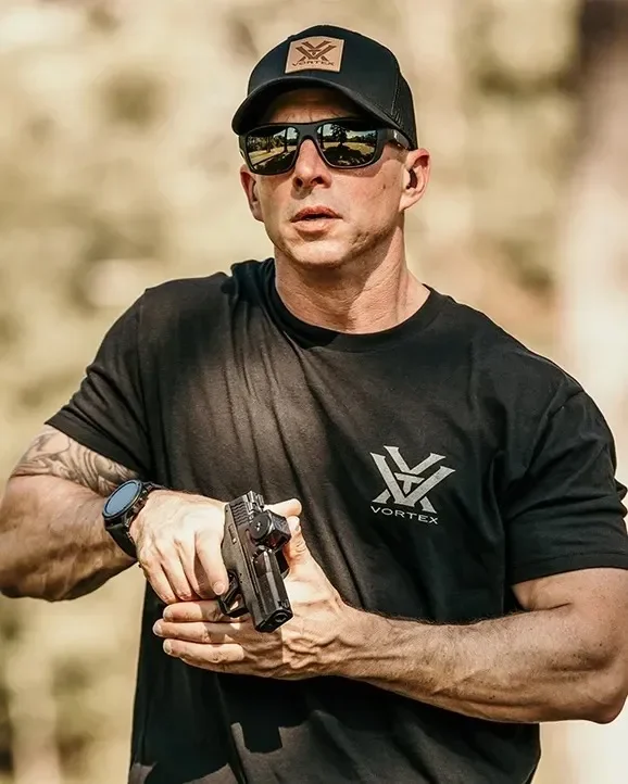 Atirador segurando pistola com o red dot Vortex Defender-CCW Enclosed Solar