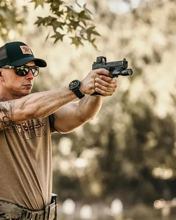 Atirador no estande mirando com o red dot Vortex Defender-ST Enclosed Solar